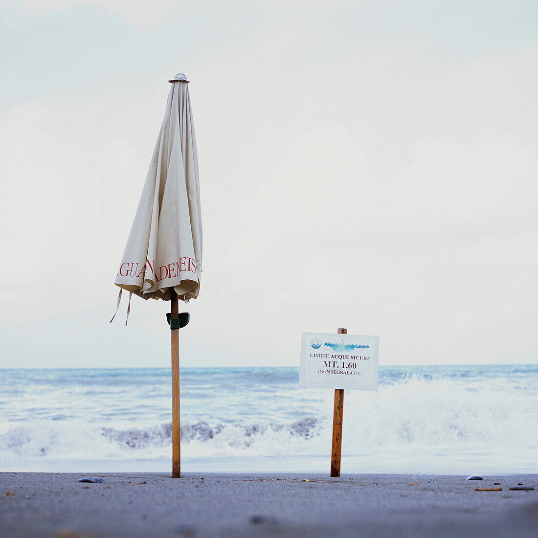 zusammengeklappter Sonnenschirm am Strand, Levanto, Ligurien, Italien
