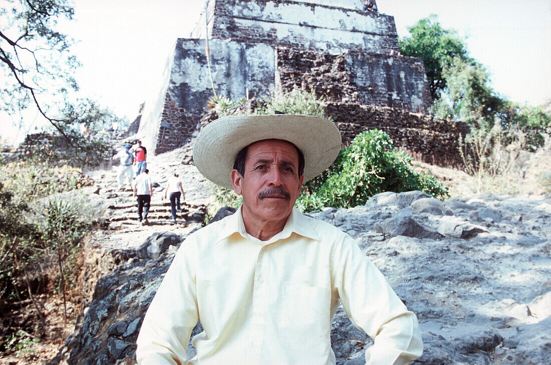 Portrait von einem mexikanischen Mann, Mexiko, Mittelamerika, schaut in die Kamera, trägt einen Hut, Sonnenschutz, Markenzeichen, typisch, gelbes Hemd, Bart, bärtig, freundlich, Reise, Fernreise, Urlaub, Rundfahrt, Sehenswürdigkeit, auf dem Land, Führer