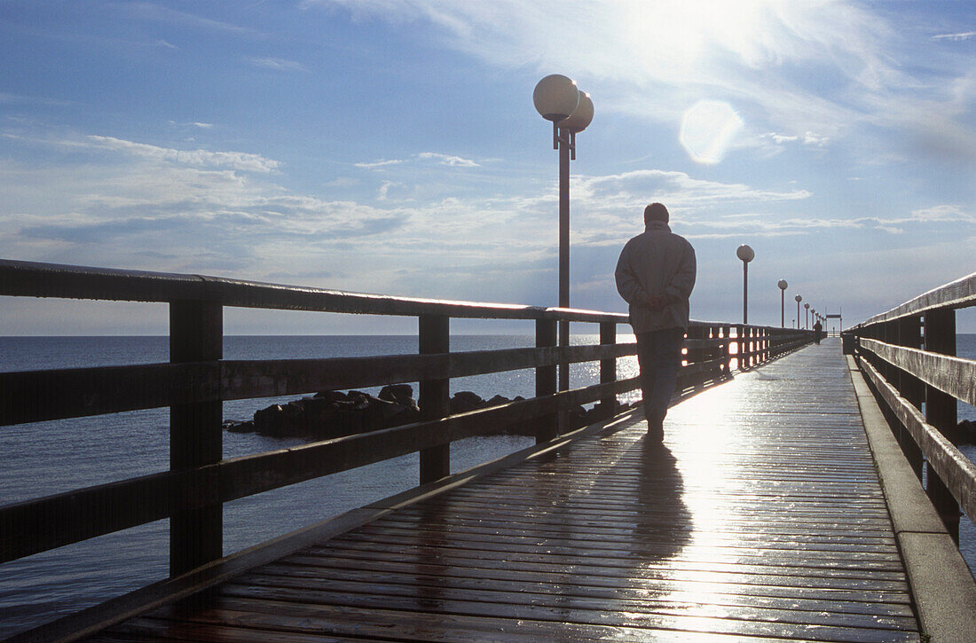 Mann im Gegenlicht auf Seebrücke an der Ostsee, Dierhagen, Mecklenburg Vorpommern, Deutschland