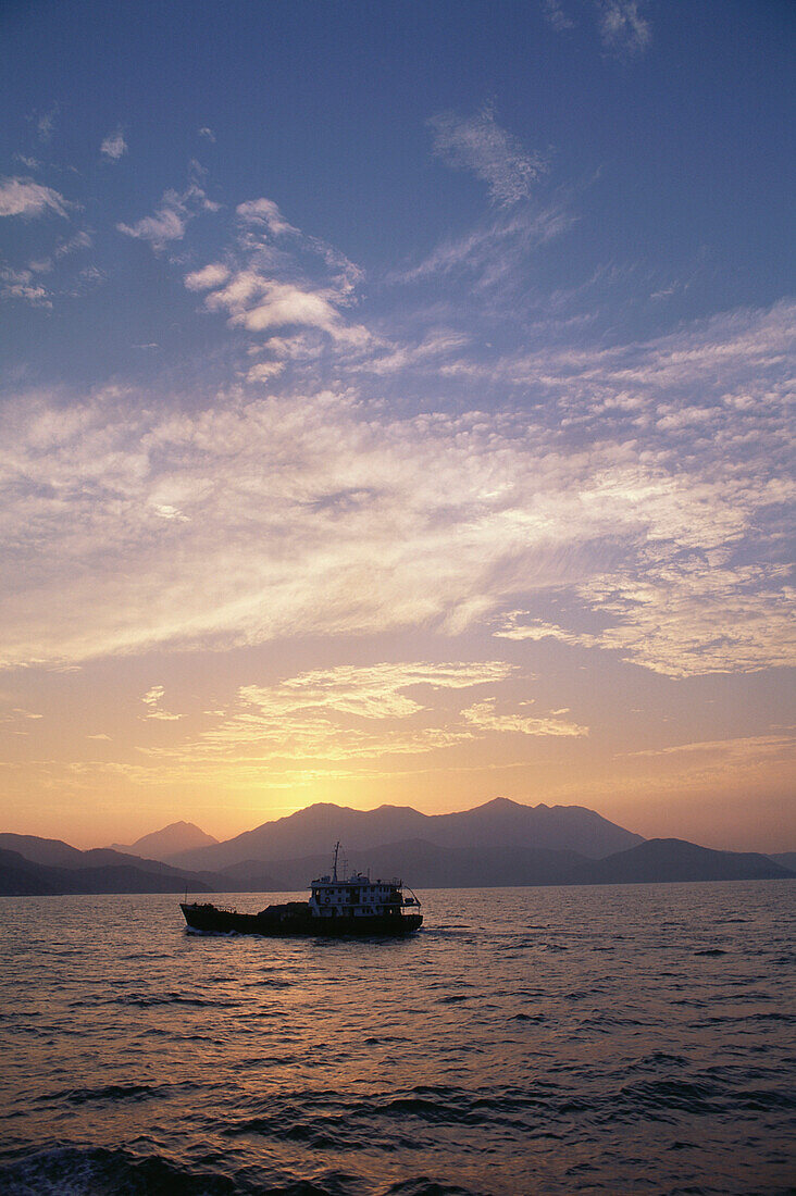 A boat at dusk, channel between islands, Hongkong, China