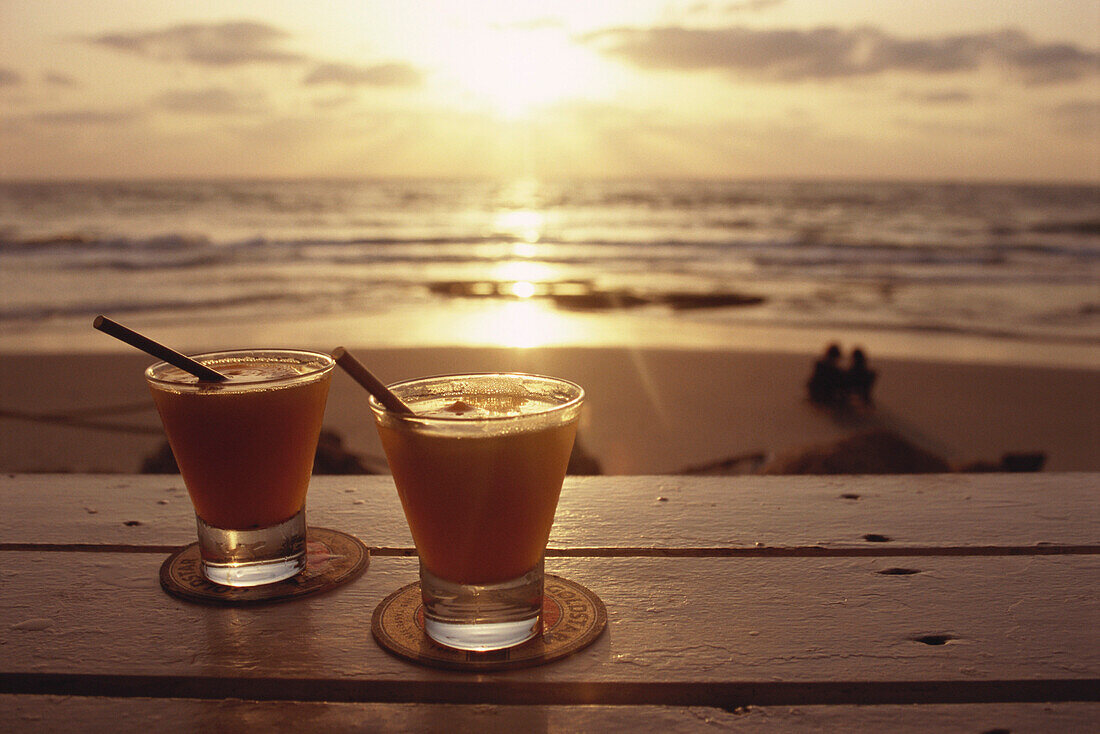 Two cocktails on a table near the beach, a couple watching the sunset, Tel Aviv, Israel