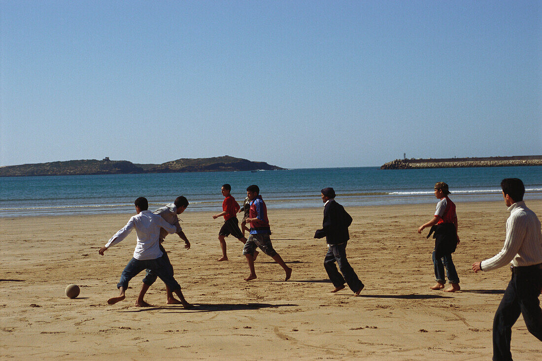 Junger Erwachsene spielen Fussball am Strand, Essaouira Coastal Resort, Marokko, Afrika