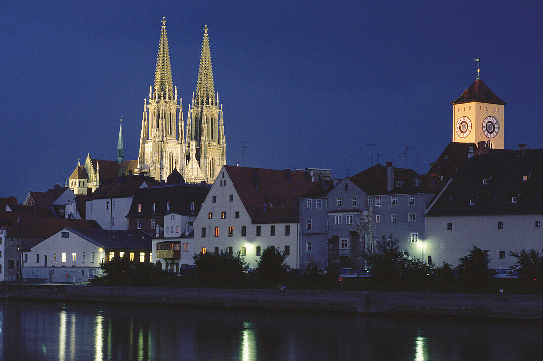 View over Danube river to Regensburg Cathedral and city hall tower at night, Regensburg, Bavaria, Germany