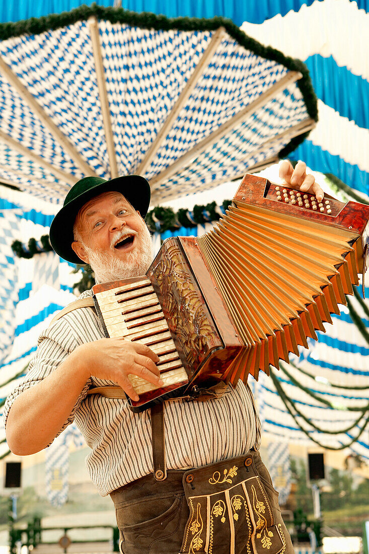 Mann in bayrischer Tracht spielt Akkordeon