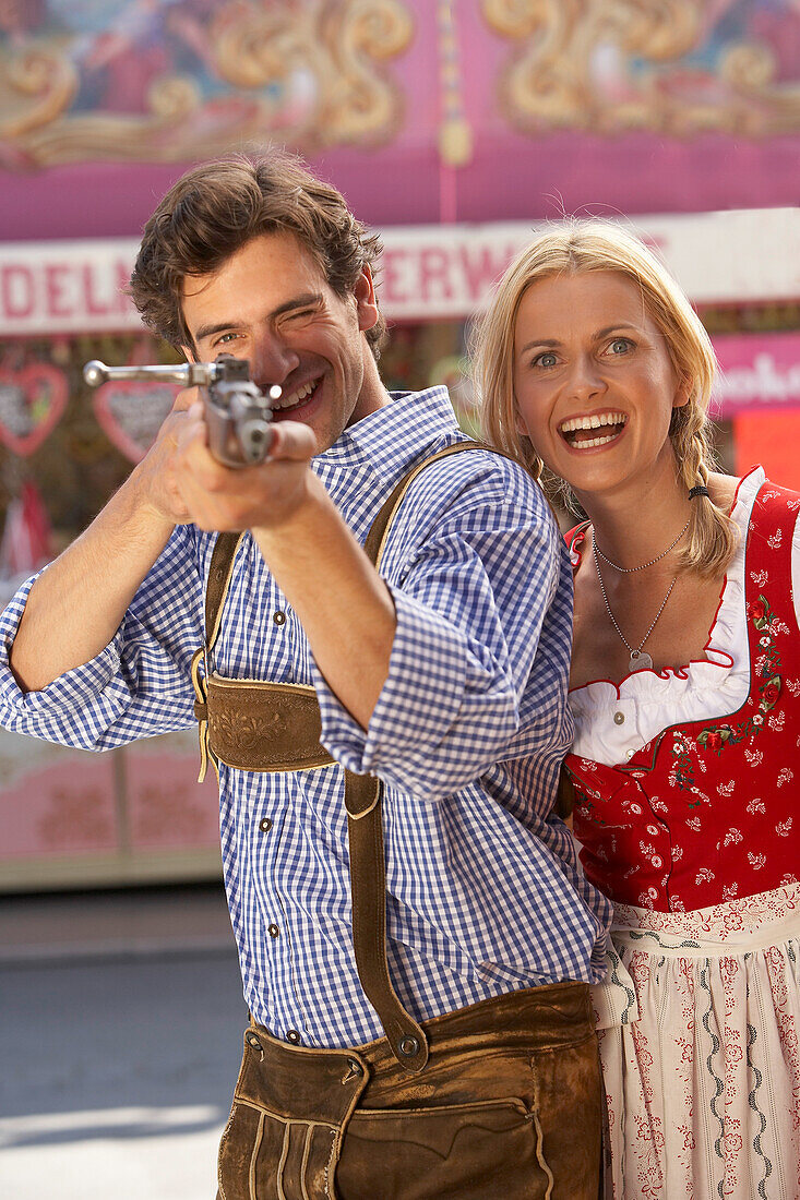 Mann zieht mit Gewehr auf die Kamera, Oktoberfest, München, Bayern, Deutschland