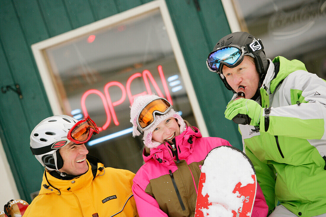 Three skiers in front of T-Bar pub, Castle Mountain ski resort, Alberta, Canada