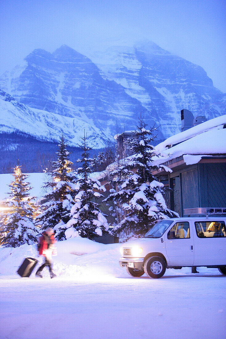 Skiers and van in front of Lake Louise Inn, Lake Louise, Alberta, Canada