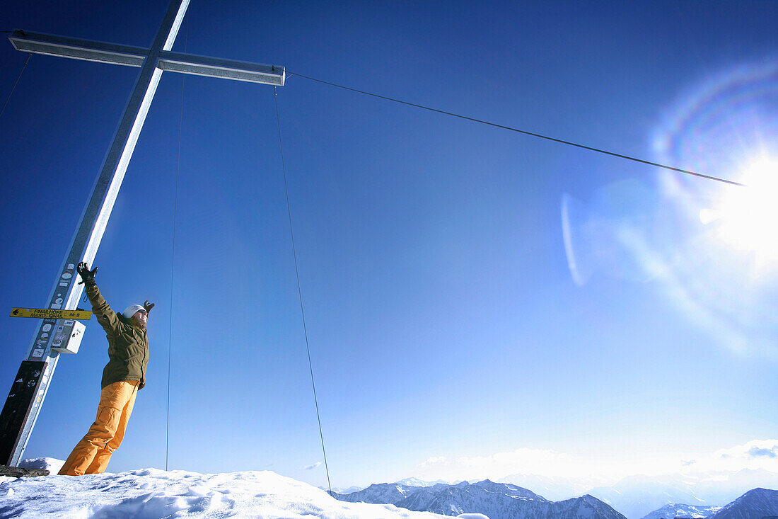 Cheering skier near summit cross, Grawand peak, Schnals Valley, Oetztal Alps, South Tyrol, Italy, MR
