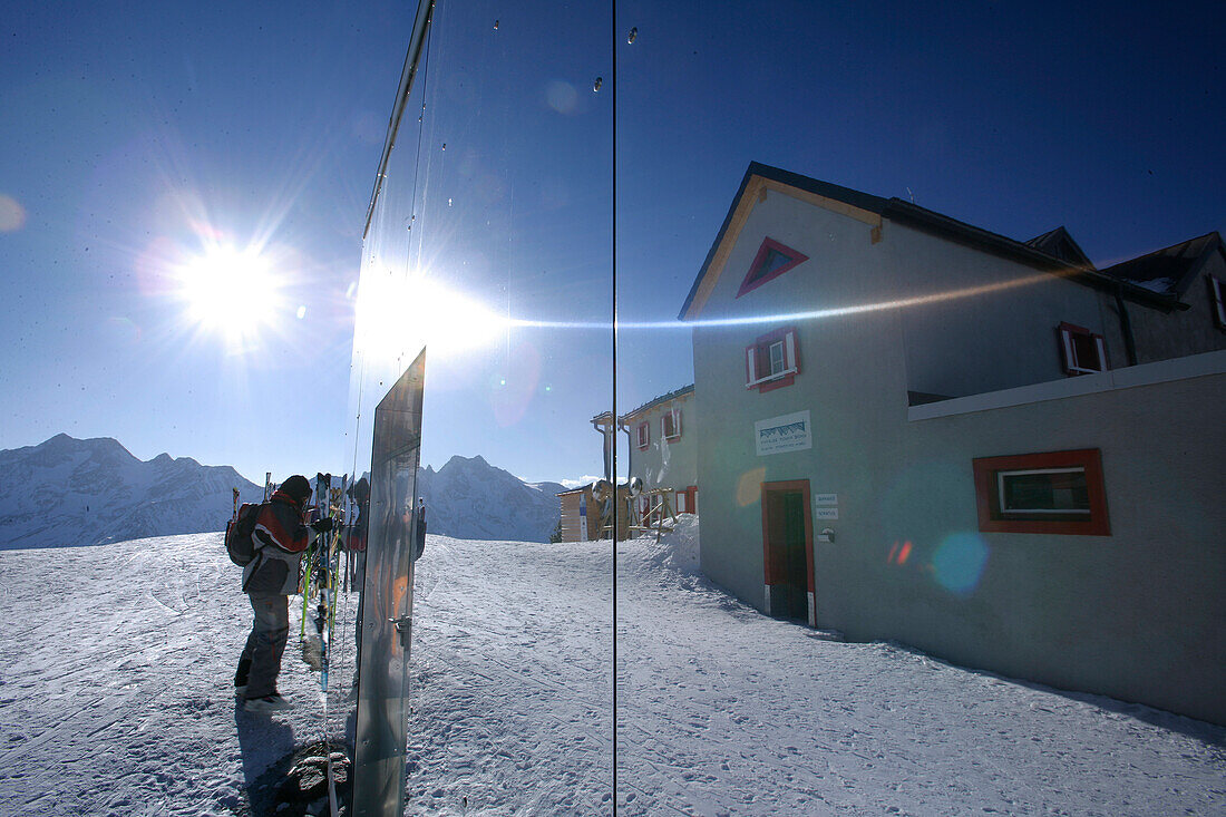 Skifahrer und Skihütte Bella Vista spiegeln sich in einer Fassade, Schnalstal, Südtirol, Italien