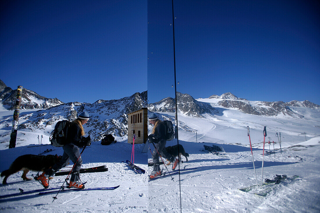 Reflection of a skier with dog on facade, alpine hut Bella Vista, Schnals valley, South Tyrol, Italy, MR