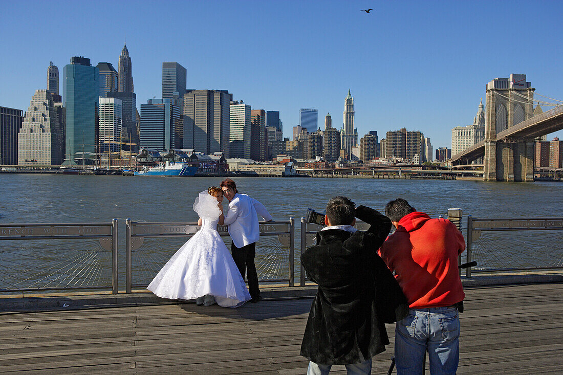 Smiling for a wedding photo in front of the East River and Brooklyn Bridge, Manhattan