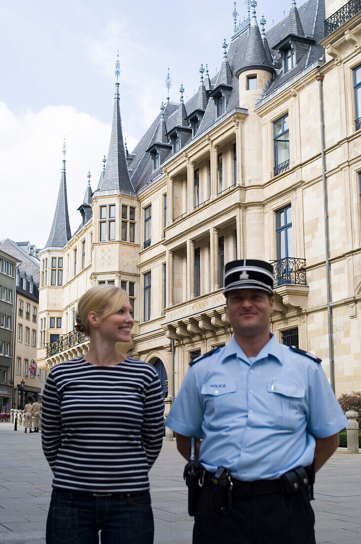 Frau und Polizist spazieren vor dem Großherzoglichen Palais, Luxemburg