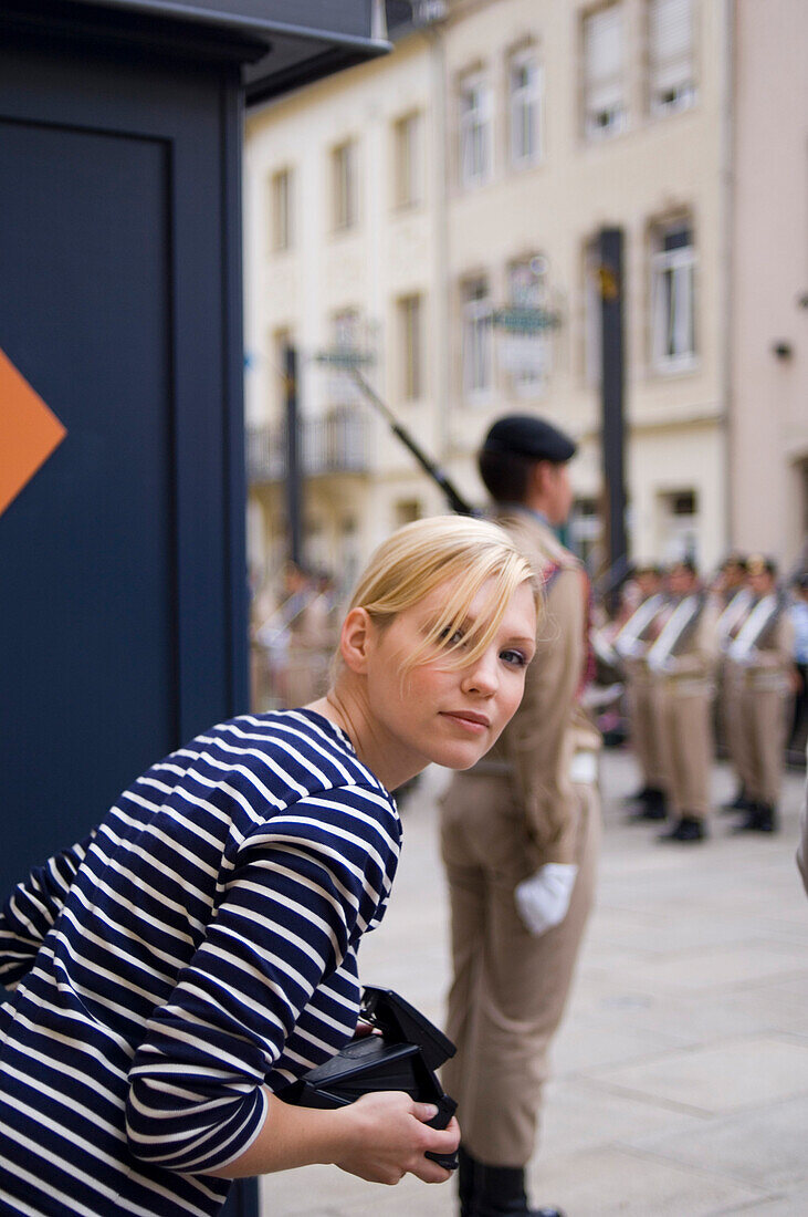 Young woman watching changing of the guard at Grand Ducal Palace, Luxembourg, Luxembourg