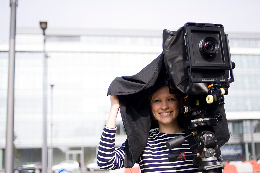 Frau steht hinter einer Großbildkamera und fotografiert, Luxemburg