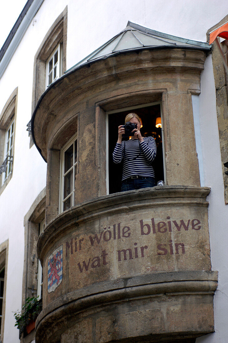 Woman taking picture from window, Luxembourg