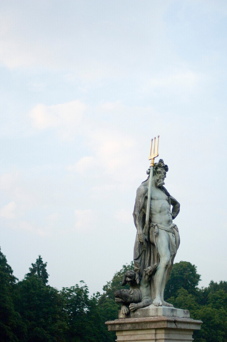 Skulptur des Neptun vor wolkenverhangenem Himmel, Nymphenburg, München, Bayern, Deutschland