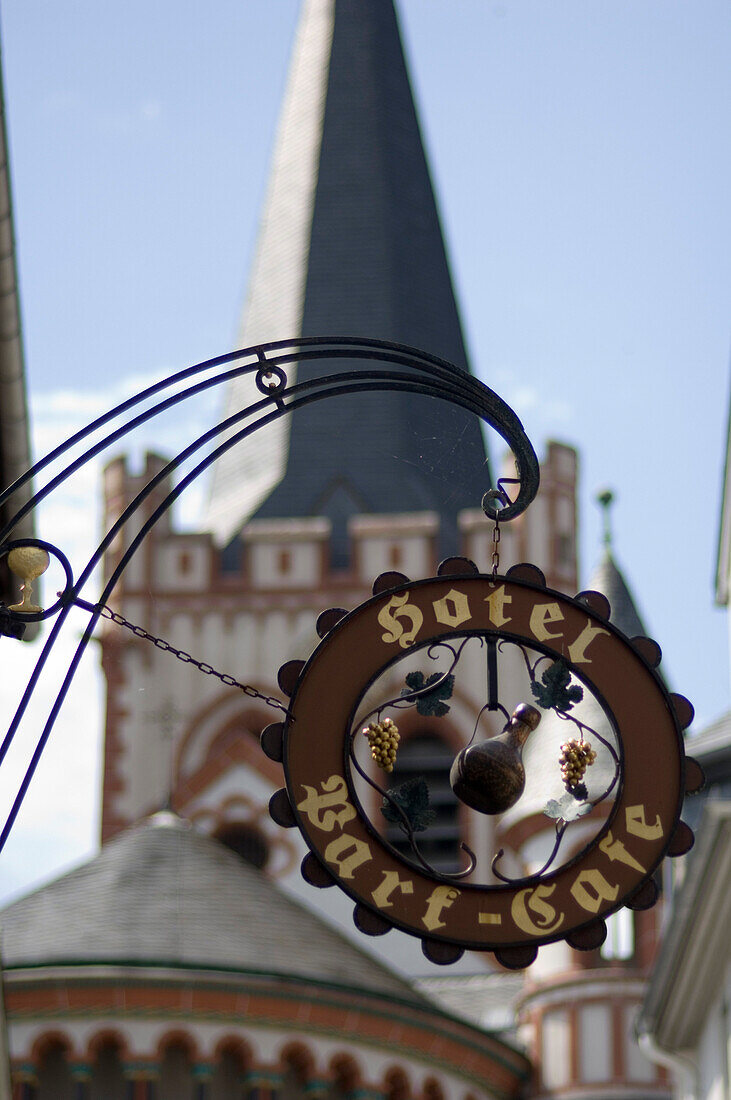 Ein Hotelschild und der Kirchturm von Bacharach, Rheinland-Pfalz, Deutschland