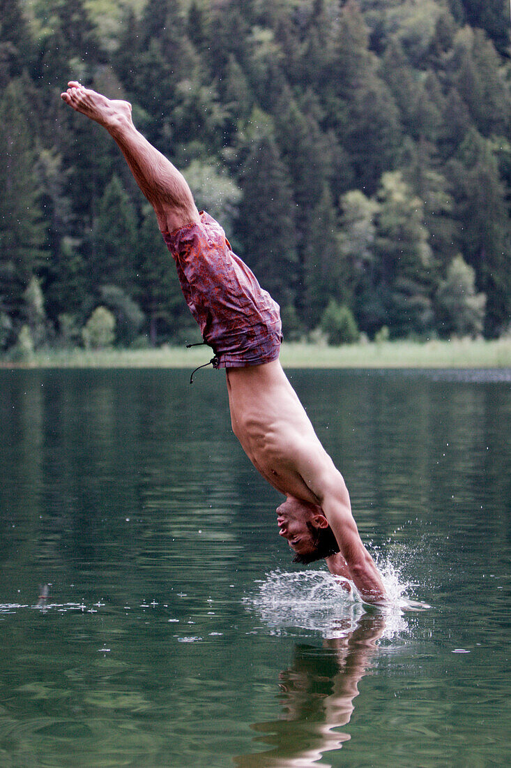 Junger Mann springt ins Wasser, Füssen, Bayern, Deutschland