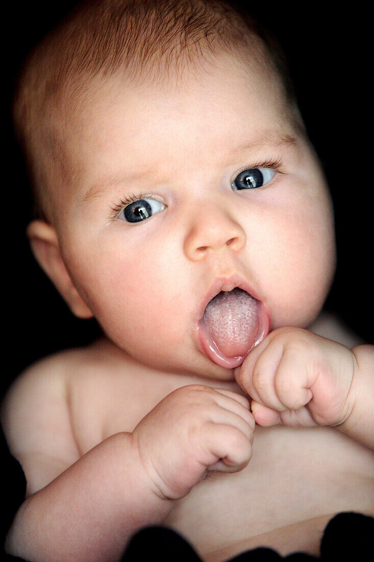 Baby sticking out tongue, Doesingen, Bavaria, Germany