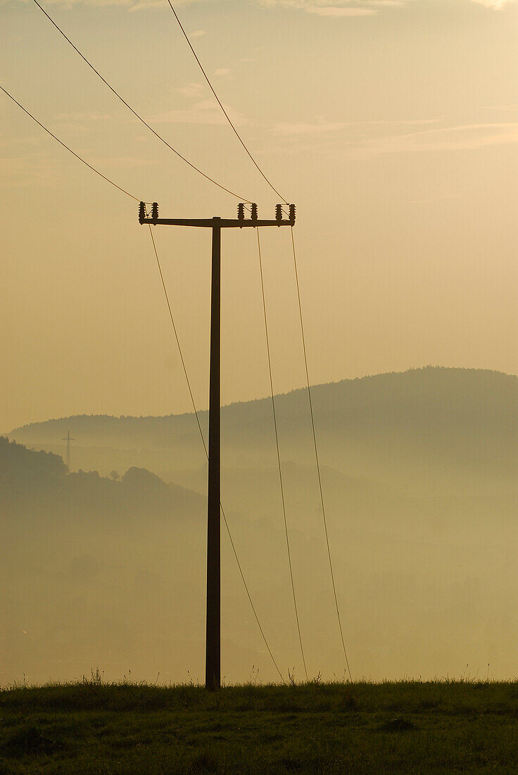 Pylon and morning haze at Hoerselberge, Thuringia, Germany