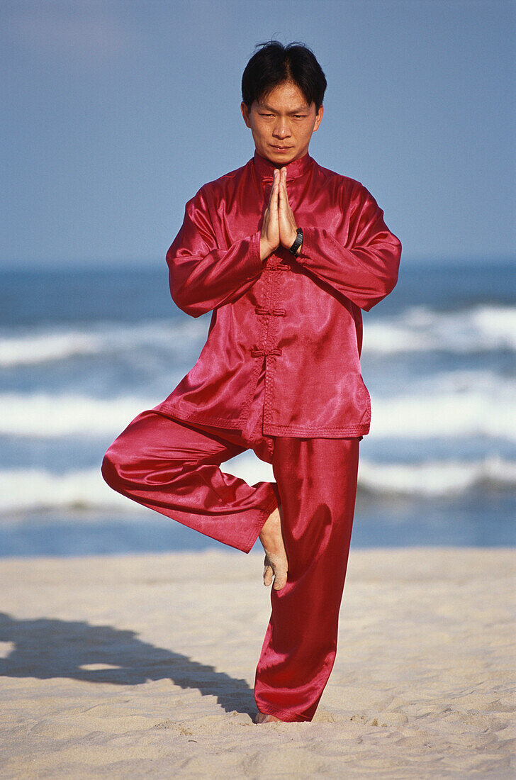 Mann macht Tai Chi Übungen am Strand, China Beach und Meer, Harmonie, Ausglichenheit, Energie, Meditation, Danang, Vietnam