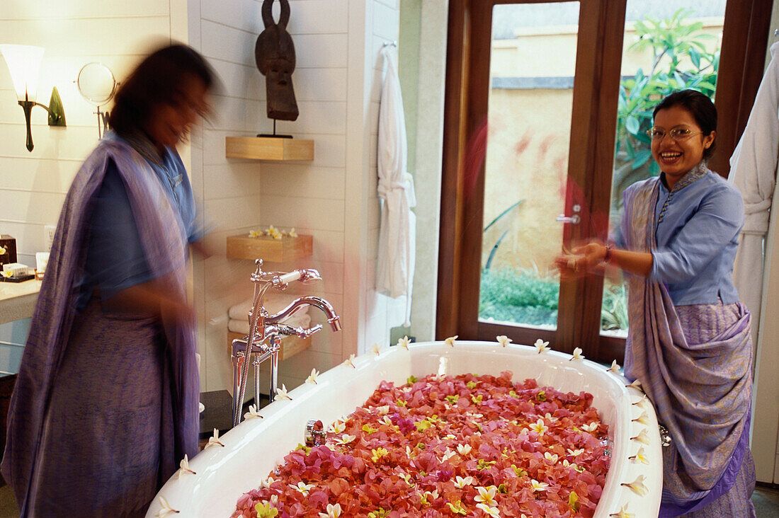 Women filling a bath with flower petals, Bathroom, Relaxation,  Hotel Oberoi, Holiday, Mauritius, Africa
