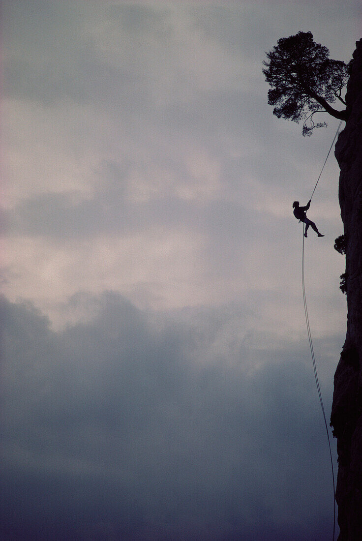 Man free-climbing, climbing up a rock face, climbing rope, sport, Cimaii, France