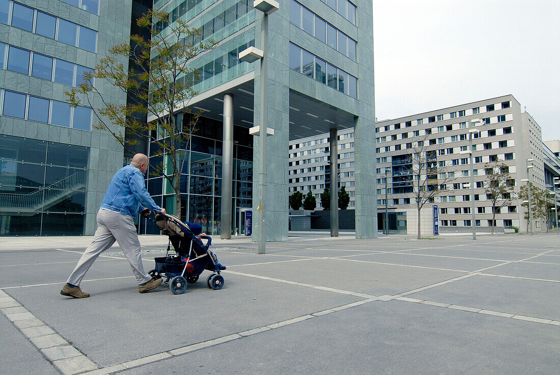 Man pushing pram in Uno City, Vienna International Centre, Vienna, Austria