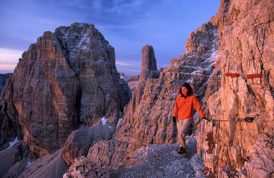 Mountaineerer at fixed rope route Bocchette with Cima Brenta alta and Guglia di Brenta, Brenta Range, Italy