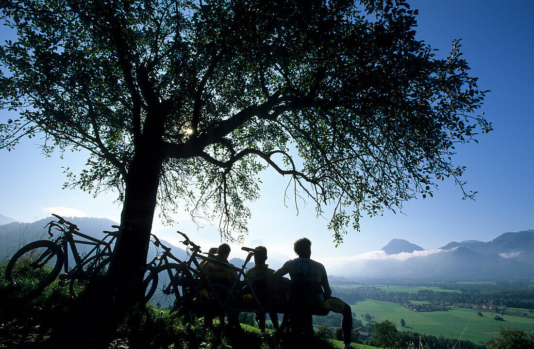 Mountainbiker rasten auf einer Bank, Samerberg, Chiemgau, Oberbayern, Bayern, Deutschland