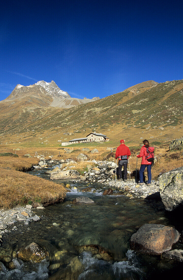 Two hickers in Es-cha valley, Piz Kesch in background, Engadin, Grisons, Switzerland