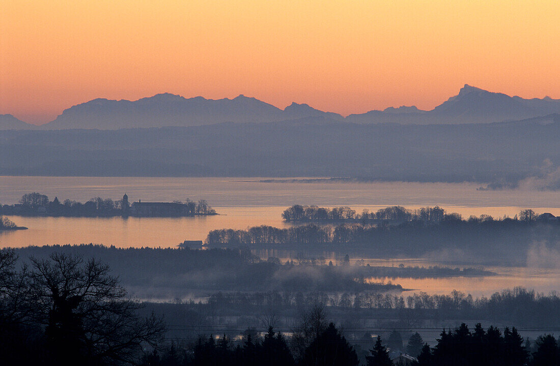 Blick über Chiemsee mit Fraueninsel auf Höllengebirge in der Morgendämmerung, Chiemgau, Oberbayern, Bayern, Deutschland