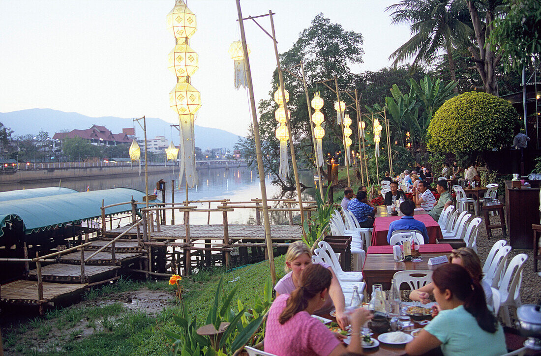 Menschen am Riverside Restaurant am Fluss Mae Nam Ping am Abend, Chiang Mai, Thailand, Asien