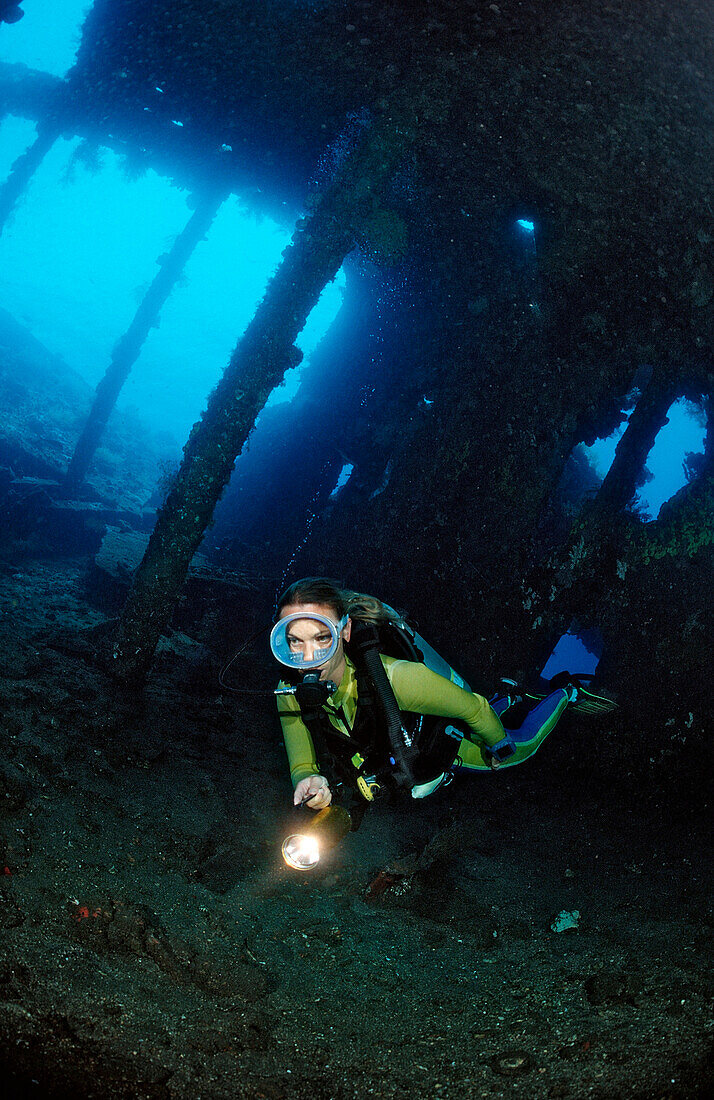 Scuba diver examines ship wreck Liberty, Indonesia, Bali, Tulamben, Indian Ocean