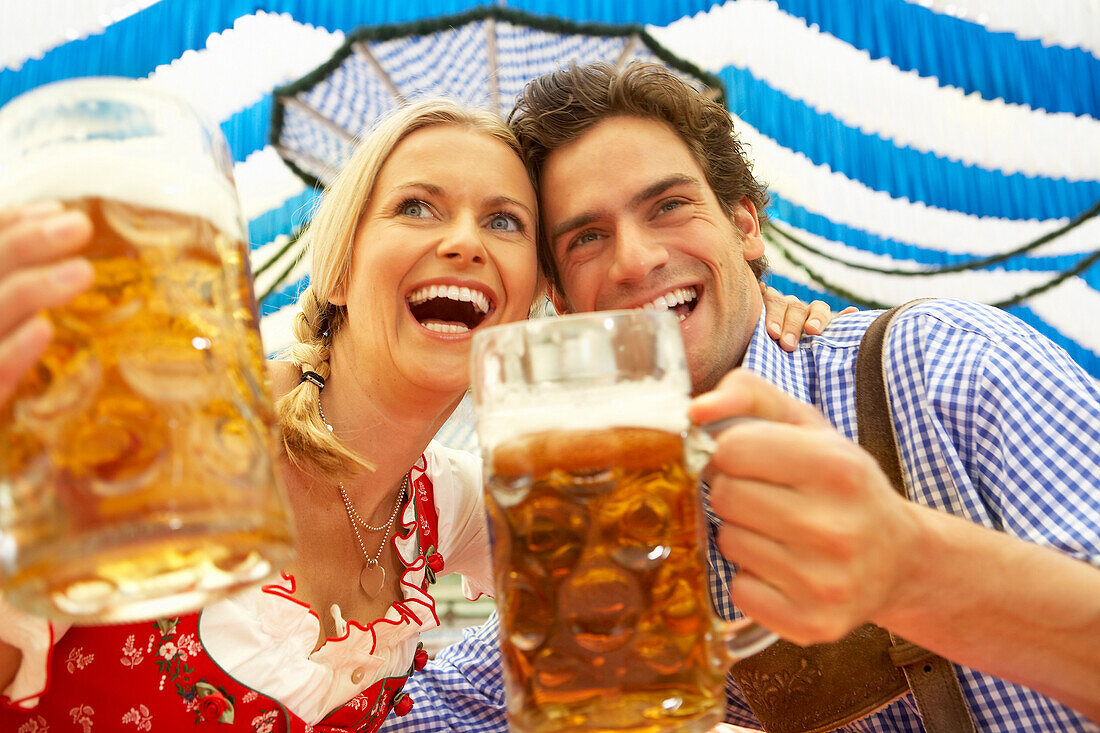 Couple clinking beer glasses in a beer tent