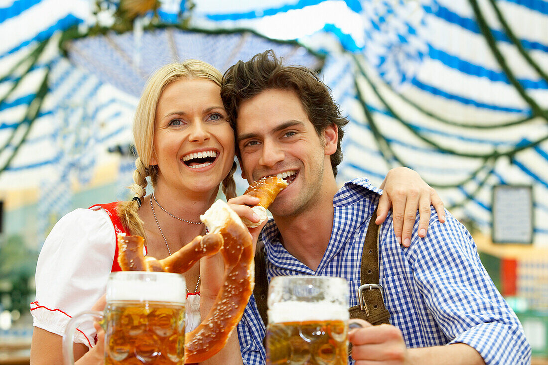 Paar mit Bier und Brezn im Bierzelt