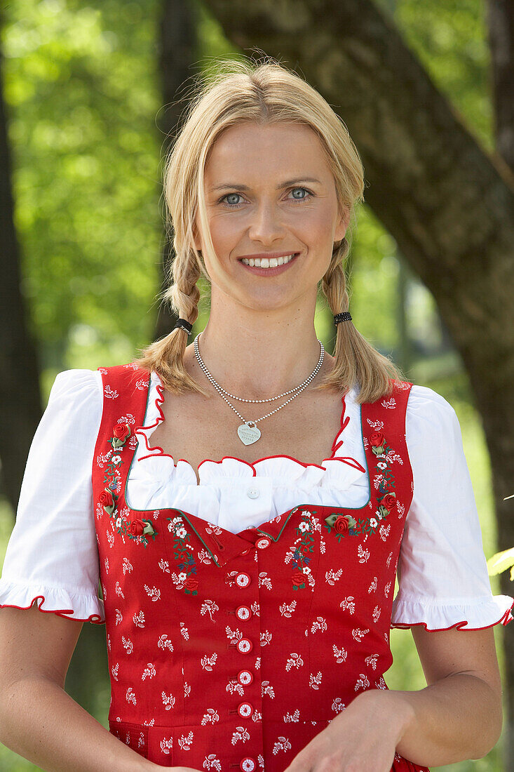 Mid adult woman wearing dirndl dress smiling at camera