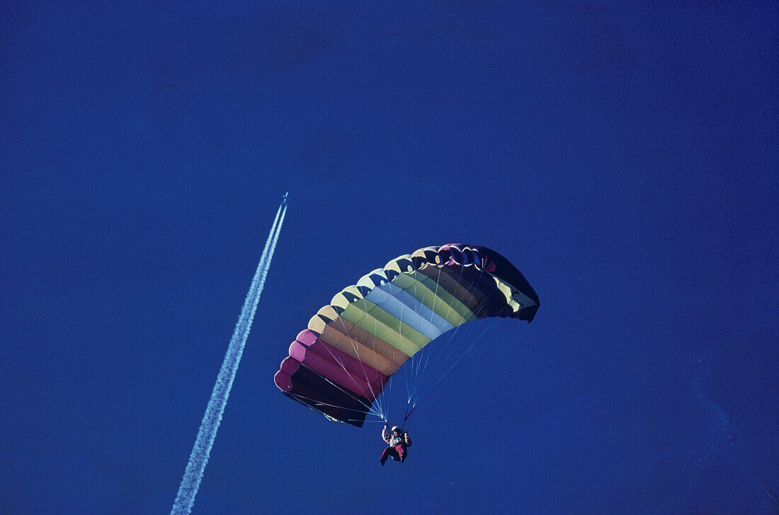 Paraglider against contrail