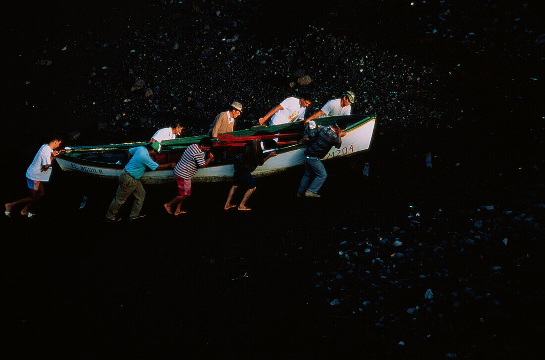 Fischer heben Boot auf den vulkanischen Strand Punta de Fuencaliente, La Palma, Kanarische Inseln, Atlantik, Spanien