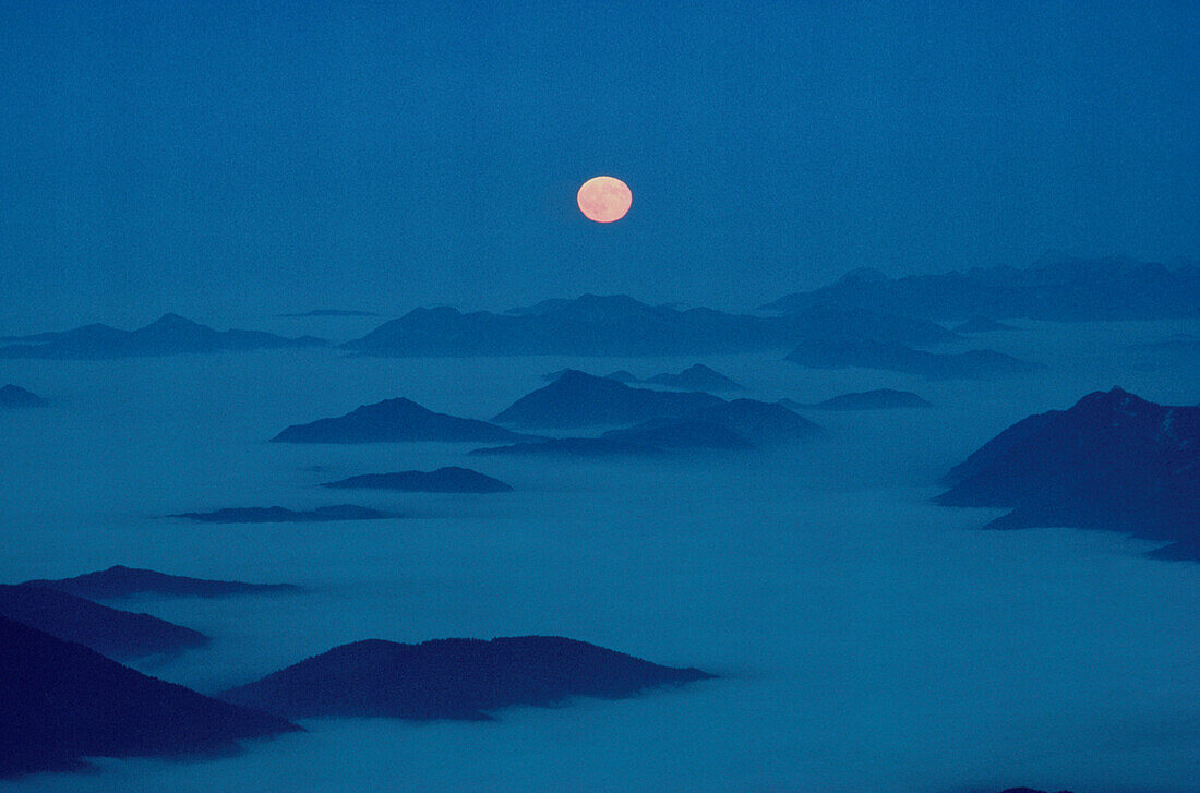 View form mount Zugspitze towards full moon at night