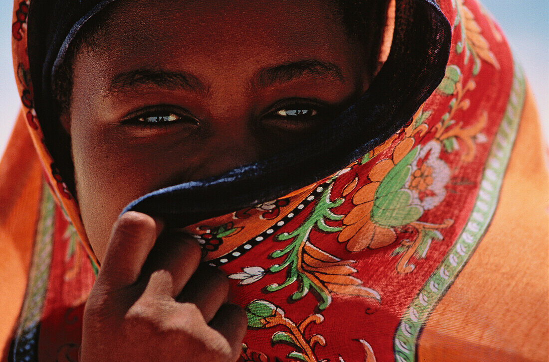 Muslimisches Mädchen hinter buntem Tuch, Bwejuu, Unguja, Sansibar, Tansania, Afrika