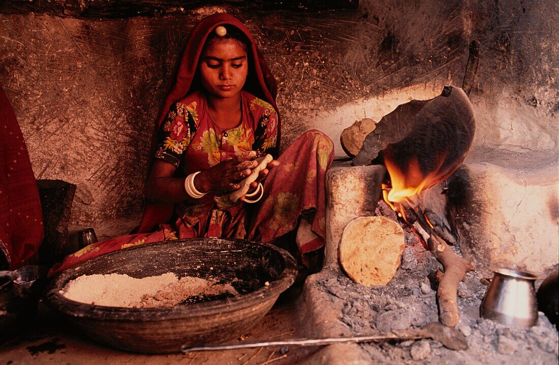 Girl baking bread, India