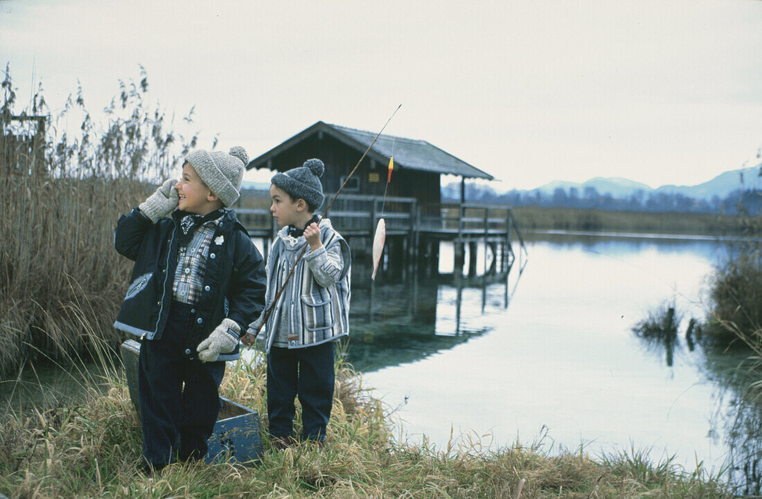 Zwei Jungen mit Angelruten am See