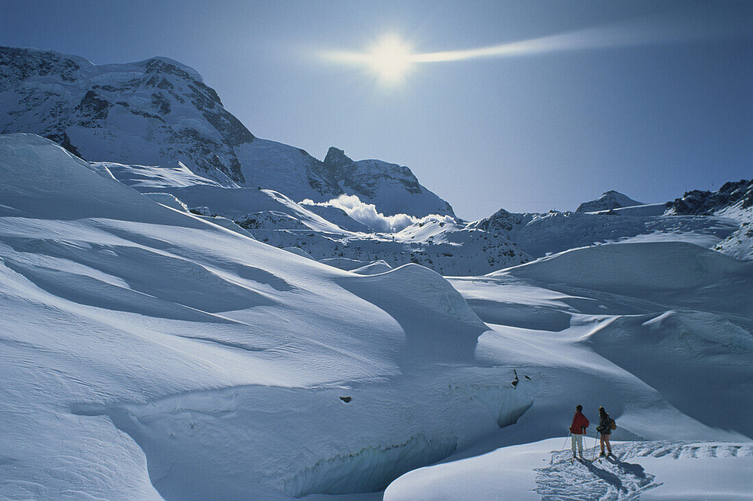 Skiers, avalanche in background, Schwarztorgletscher, Zermatt, Switzerland