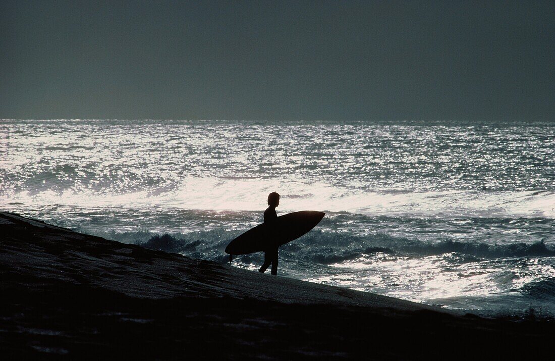 Surfer am Strand im Sonnenuntergang, Oahu, Hawaii, USA