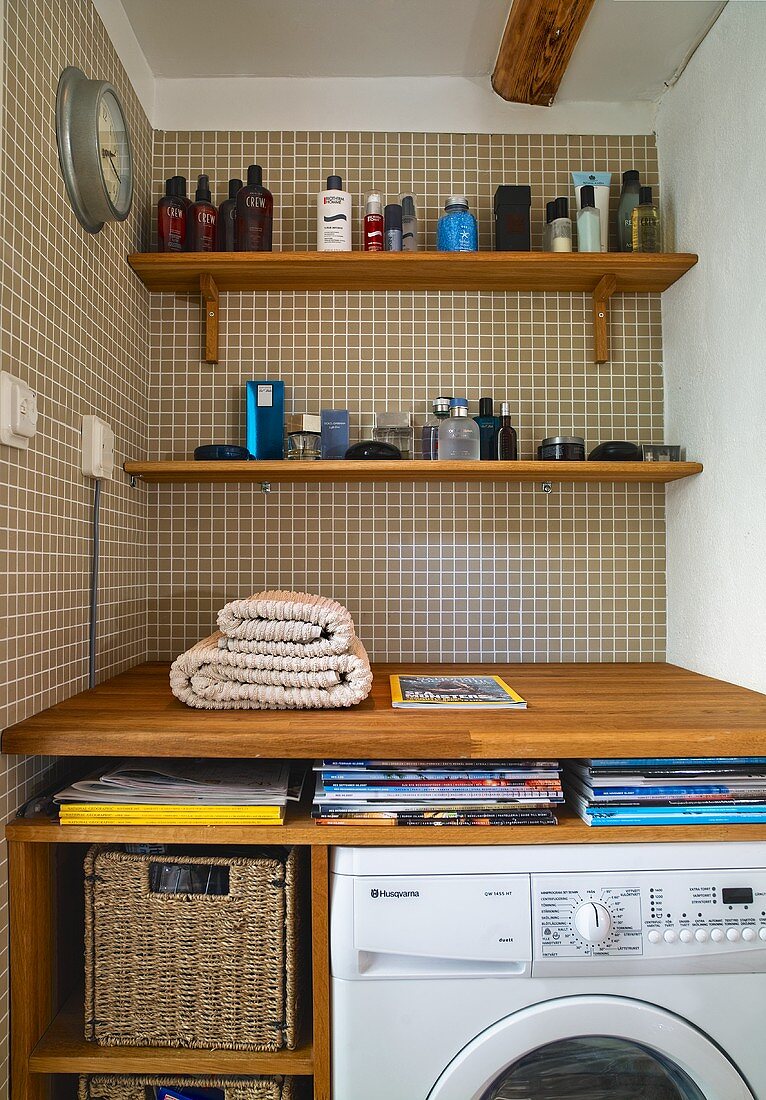 Niche with wood consoles with bathroom items in front of wall of brown tiles