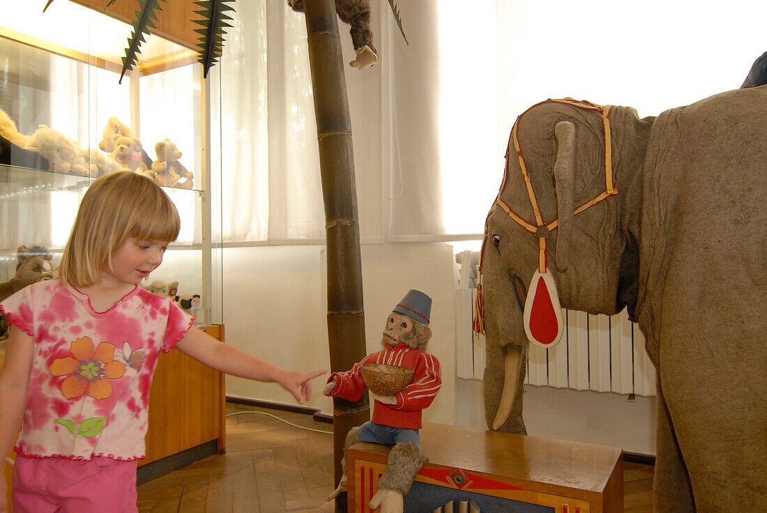 Child, girl with toy elefant and monkey in the toy museum in Sonneberg, Thuringia, Germany