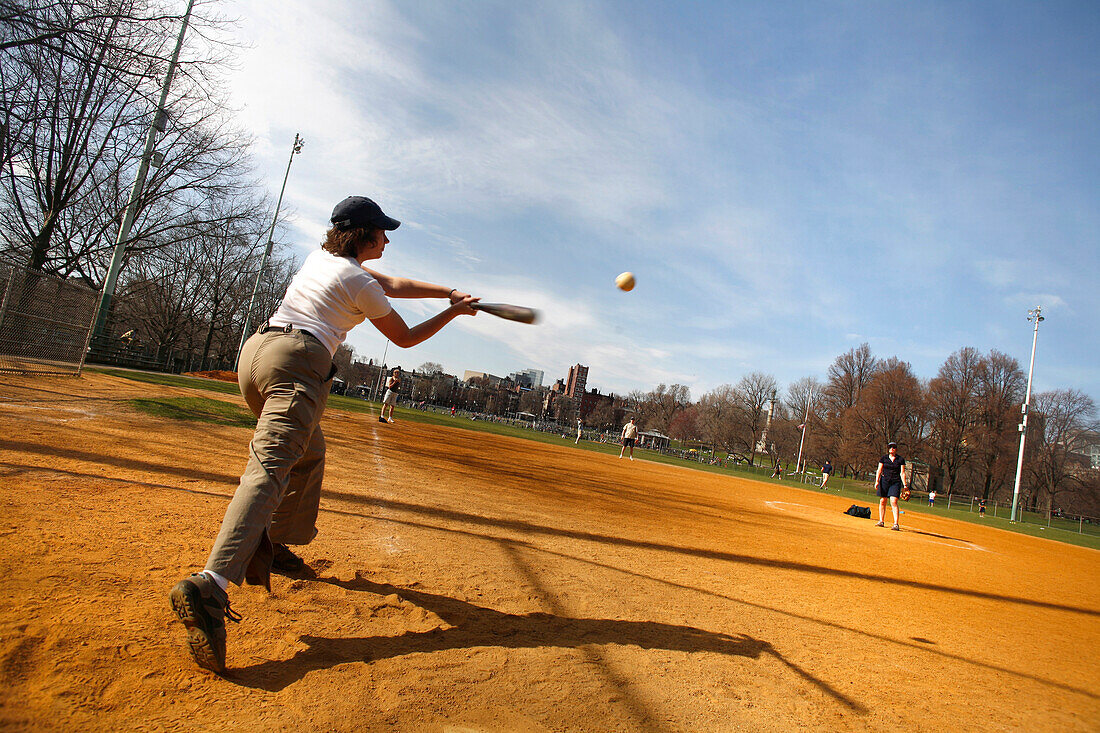 A woman playing softball on Boston Common, Boston, Massachusetts, USA