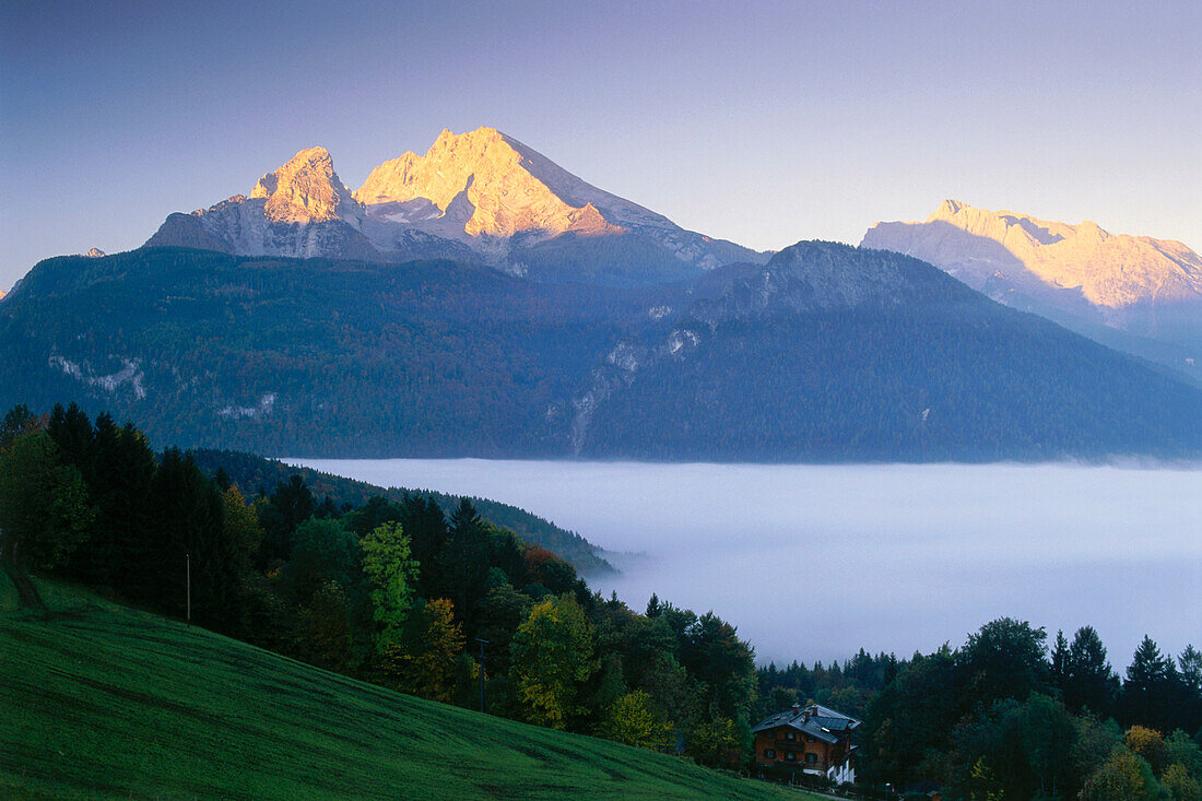 View over valley with fog to Watzmann and Hochkalter peaks, Schoenau am Koenigssee (King's Lake), Berchtesgadener Land, Bavaria, Germany