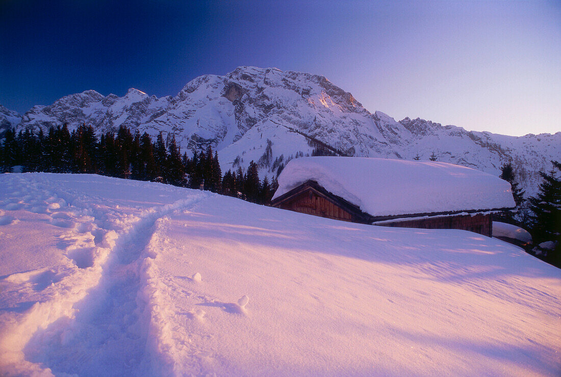 Snow covered mountain hut, Obere Ahornalm, Rossfeld ski region, Berchtesgadener Land, Bavaria, Germany